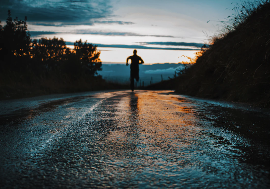 Lone runner on a road at dusk