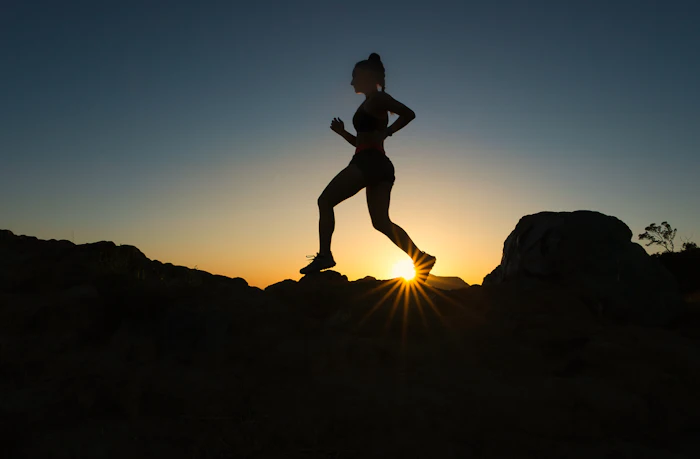 Runner silhouetted at sunset