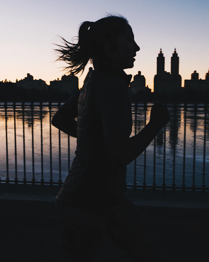 Runner silhouetted against a city skyline
